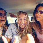 three happy teenagers on a road trip